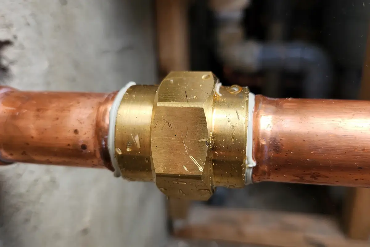New brass coupling joint installed on copper piping